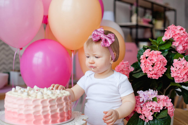 little girl on the table with a birthday cake and balloons - Foto, Bild
