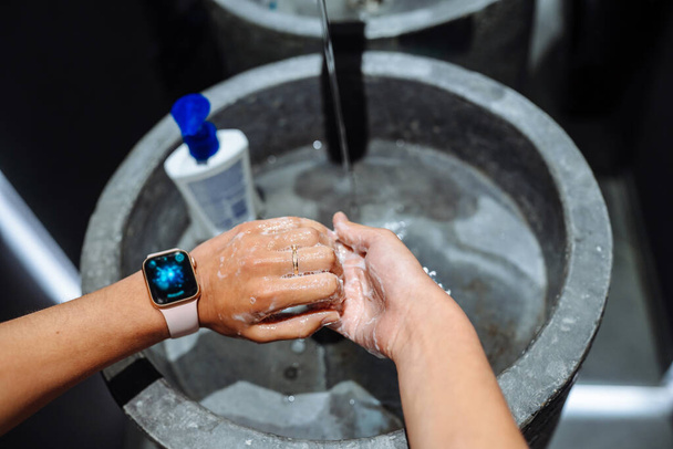 Женщина моет руки, чтобы защитить от коронавируса - Фото, изображение