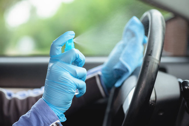 Driver handles car steering wheel with antiseptic close up. - 写真・画像