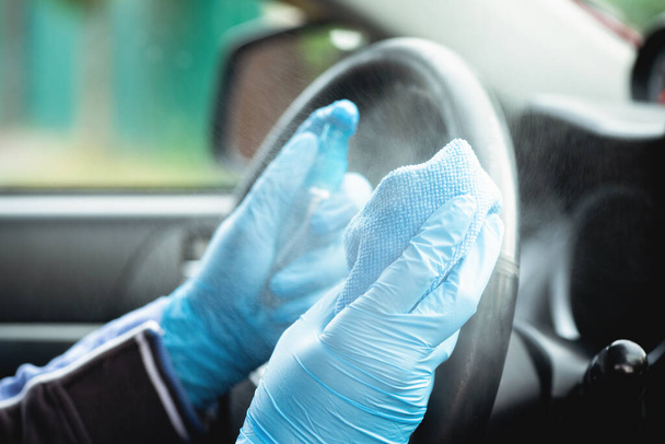 Driver handles car steering wheel with antiseptic close up. - 写真・画像