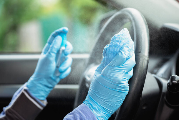 Driver handles car steering wheel with antiseptic close up. - Photo, image