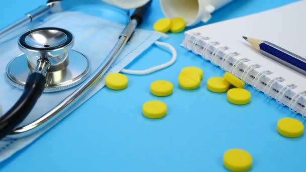 Terveydenhuollon ja lääketieteen käsite keltaiset pillerit, stetoskooppi ja paperi Notebook
 - Materiaali, video