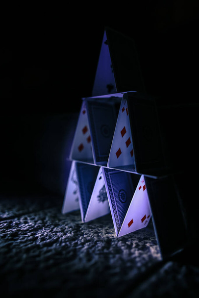 Fadenscheiniger Stapel Spielkarten in scheinbar stabilem Kartenhaus gestapelt - Foto, Bild