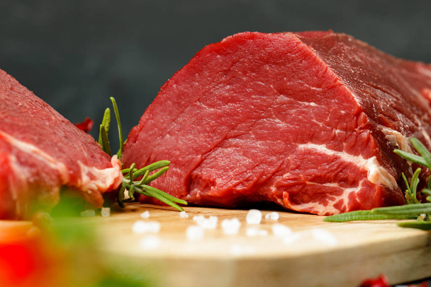 Slice of raw beef fillet on wooden board - Фото, зображення