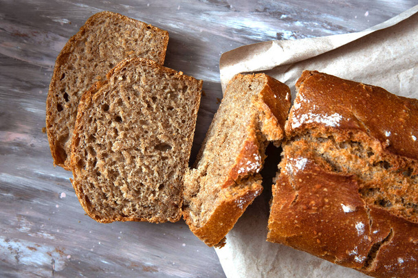 Freshly baked homemade sourdough bread, sliced on gray background. - Zdjęcie, obraz