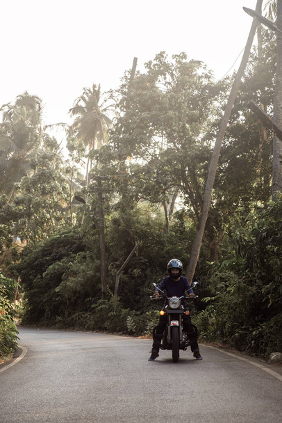 Un hombre en motocicleta en camino en la aldea de GOA
 - Foto, imagen