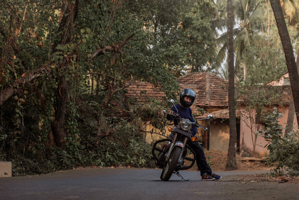 Ein Mann auf dem Motorrad unterwegs in GOA Dorf - Foto, Bild