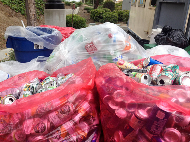 Aluminiumblikjes in rode plastic zakken in een gemeenschapsrecyclingbedrijf - Foto, afbeelding