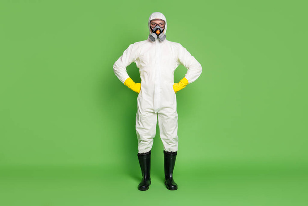 Full length body size view of his he nice serious disinfectant wearing gas mask sars ncov prevention public place social distance watch control order isolated over green pastel color background - Foto, immagini