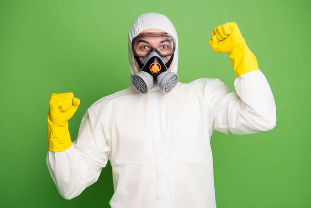 Close-up portrait of his he nice professional disinfectant wearing gas mask rubber gloves celebrating having fun decontamination good news isolated over green pastel color background - Foto, afbeelding