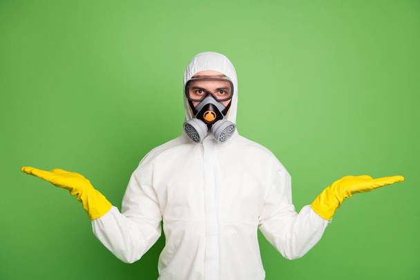 Portrait of his he nice professional disinfectant workman wearing gas mask holding on two palms copy space quarantine restrictions choose choice decide isolated over green pastel color background - Fotó, kép
