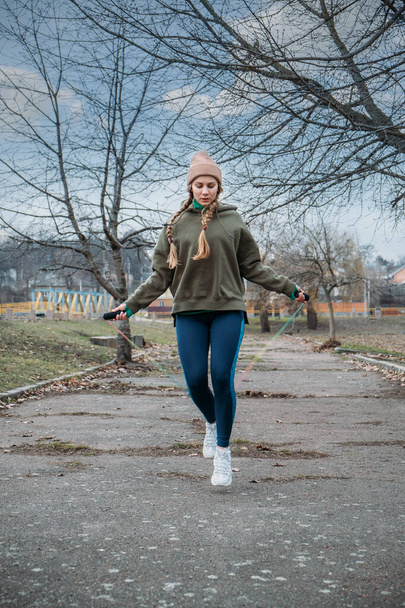 Fitness in the fresh air, outdoor workout. Safer outside. Fitness woman jumping outdoor in urban environment. Workout outdoor classes at the city parks and fields. - Photo, Image