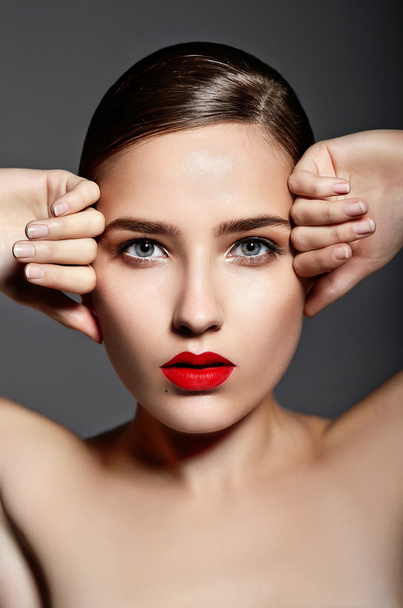 High fashion look.glamor closeup portrait of beautiful sexy stylish brunette Caucasian young woman model with bright makeup, with red lips, with perfect clean skin in studio - 写真・画像