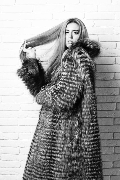 fashionable sexy woman in fur on brick wall studio background - Foto, imagen