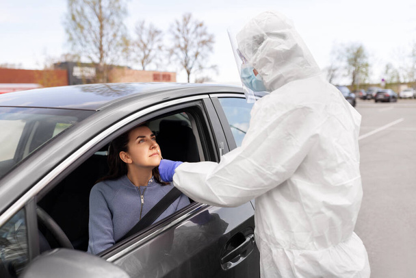 healthcare worker making coronavirus test at car - Foto, Imagem