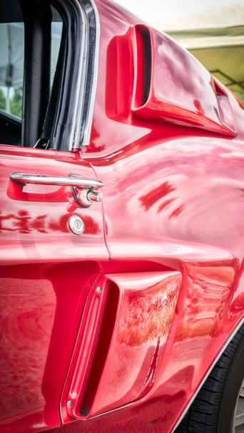 Η πλευρά του αέρα μπάλες της δεκαετίας του εξήντα αμερικανικό σπορ αυτοκίνητο σε κόκκινο. - Φωτογραφία, εικόνα