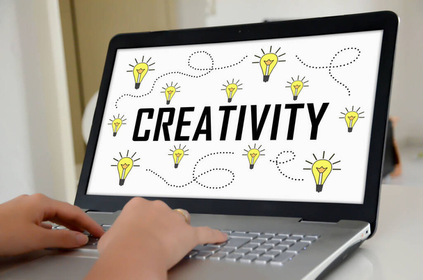 Hands on a laptop with screen showing creativity concept - Foto, Imagen