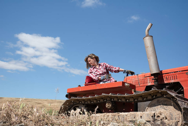 Фермерша водит трактор по своей ферме
 - Фото, изображение