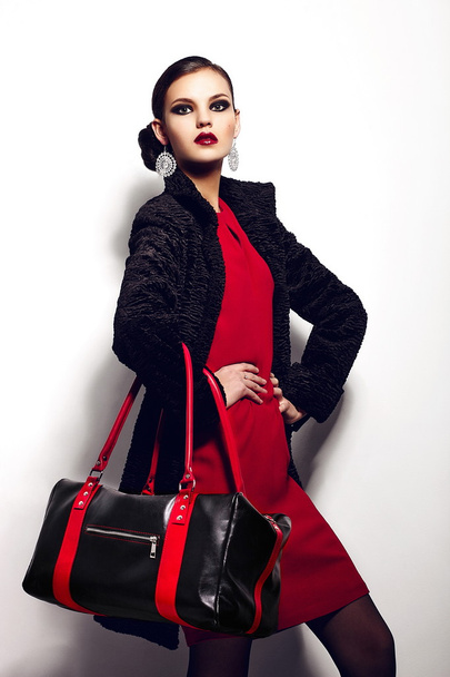High fashion look.glamor closeup portrait of two beautiful sexy stylish brunette Caucasian young woman model in black jacket with bag bright makeup, with perfect clean skin in studio - 写真・画像