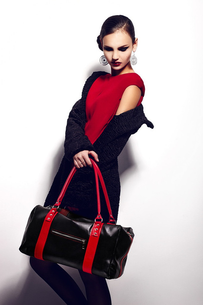 High fashion look.glamor closeup portrait of two beautiful sexy stylish brunette Caucasian young woman model in black jacket with bag bright makeup, with perfect clean skin in studio - Foto, Bild