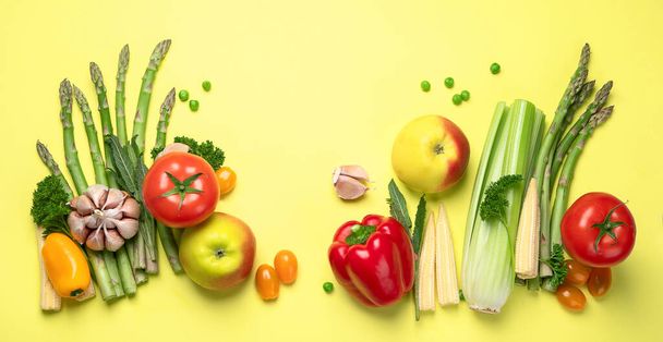 Fresh fruits and vegetables on yellow background. Healty food concept. Vegan and vegetarian diet eating. Foods high in vitamins and antioxidants. Top view - Photo, Image