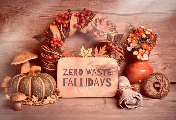 Text "Zero waste" auf Holztafel. Traditionelle herbstliche Dekorationen, getöntes Bild. Herbstkranz mit Beeren, Pilzen, Kürbissen, Blumen auf Holz. - Foto, Bild