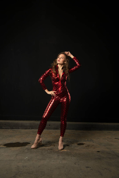 girl in a red suit posing on a black background - Φωτογραφία, εικόνα