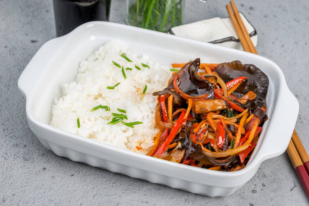 Boiled rice with stewed vegetables in a white deep plate - Foto, Imagen