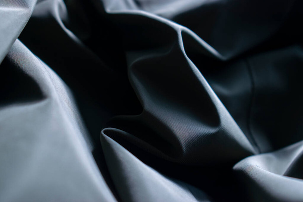Abstract wallpaper with rumpled dark blue synthetic fabric. - 写真・画像