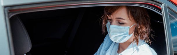 mujer con máscara médica sentada en el coche durante la pandemia de covid-19
 - Foto, Imagen