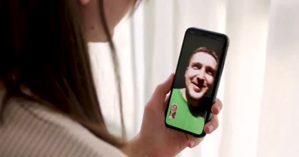 Mujer hablando con un hombre en un smartphone de videollamada
 - Metraje, vídeo