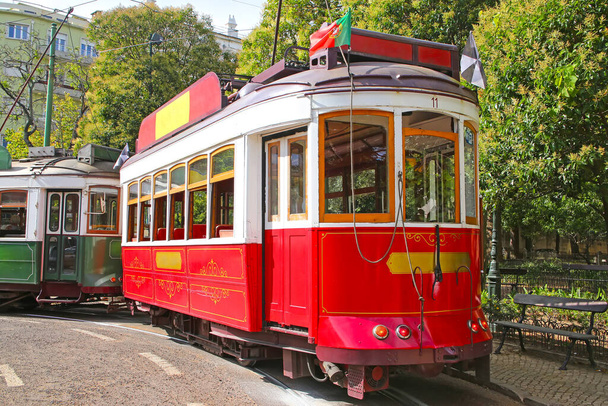 Historische rode tram tegen bomen, deel van het tramnet sinds 1873, Lissabon, hoofdstad van Portugal.  - Foto, afbeelding