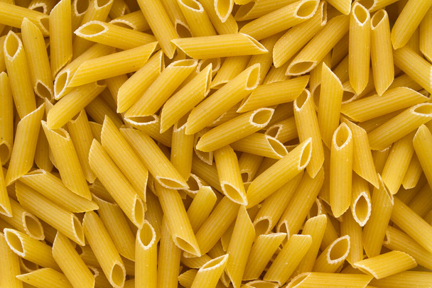 Penne pasta volledige frame achtergrond close-up - Foto, afbeelding