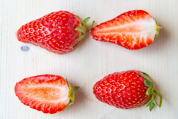 Ripe strawberries on a wooden surface - 写真・画像