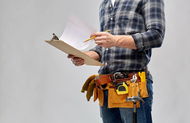 builder with clipboard, pencil and working tools - Фото, зображення