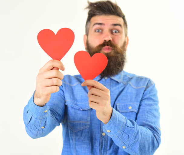 Young man with beard in denim shirt holding paper hearts - Photo, image