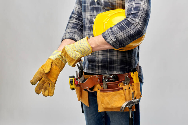 builder with gloves, helmet and working tools - Photo, image