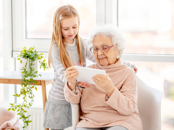 Cute girl helping old lady - Photo, image