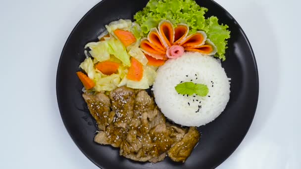 Roer gebakken varkensvlees BBQ Saus met sesamolie Strooi Sesam (DwaeGogi) geserveerd Rijst Traditionele Koreaanse Food Style op Black Plate Decorate Groenten topview - Video