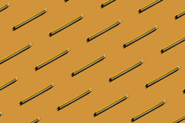 Pattern of gold and silver pencils on gold background. - Photo, image