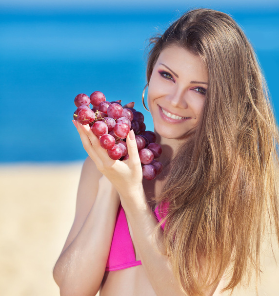 Portrait of beautiful woman with grapes in hands in summer outdoor - Foto, Imagen