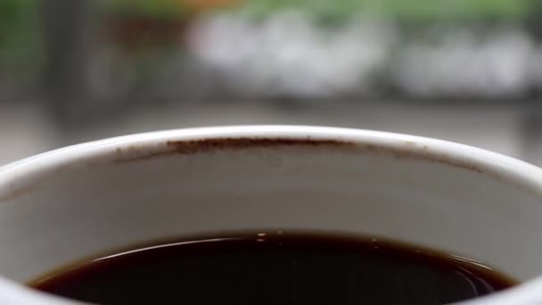 Una tazza di caffè nero raffreddato nel tempo con macchia di caffè. Aspettare qualcuno o rilassarsi
. - Filmati, video