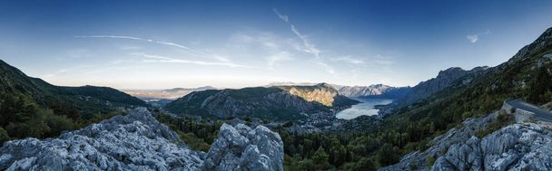 Sunrise panoramiczny poranek widok na pasmo górskie i Kotor Bay, Czarnogóra. Widok ze szczytu górskiej serpentyny. - Zdjęcie, obraz