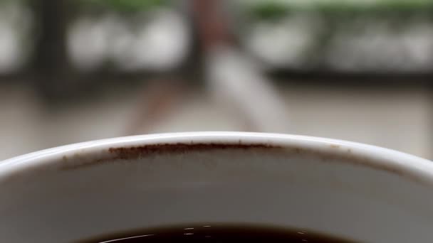 Kubek schłodzonej czarnej kawy z czasem z plamą po kawie. Czekanie na kogoś lub relaks. - Materiał filmowy, wideo