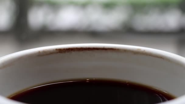 Чашка охлажденного черного кофе со временем с пятном от кофе. Ожидание кого-то или расслабление
. - Кадры, видео