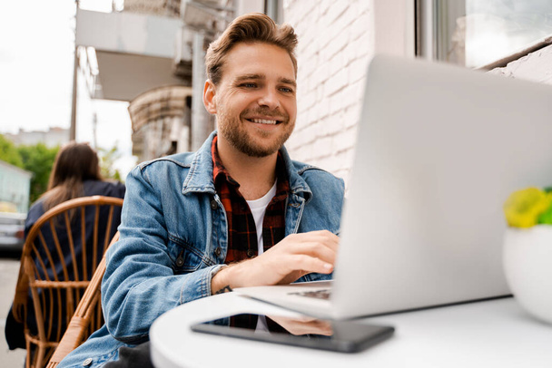 Handsome male student completing assignments online for a university, learning online on the Internet, modern technologies in education, remote training course, people lifestyle - Foto, Bild