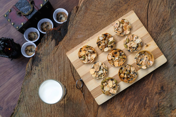 Bovenaanzicht van florentijnse koekjes met koude melk op rustieke houten tafel - Foto, afbeelding