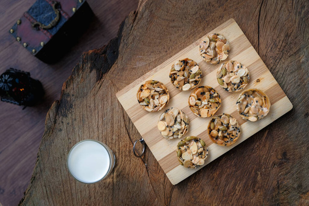 Bovenaanzicht van florentijnse koekjes met koude melk op rustieke houten tafel - Foto, afbeelding