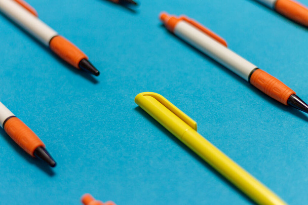 uma caneta diferente em um grupo de objetos com um fundo colorido, diferente do resto destacando o conceito colorido
 - Foto, Imagem
