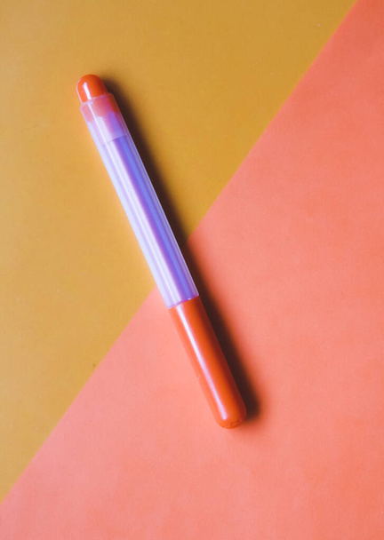 Orange felt-tip pen on an orange background. - Foto, afbeelding